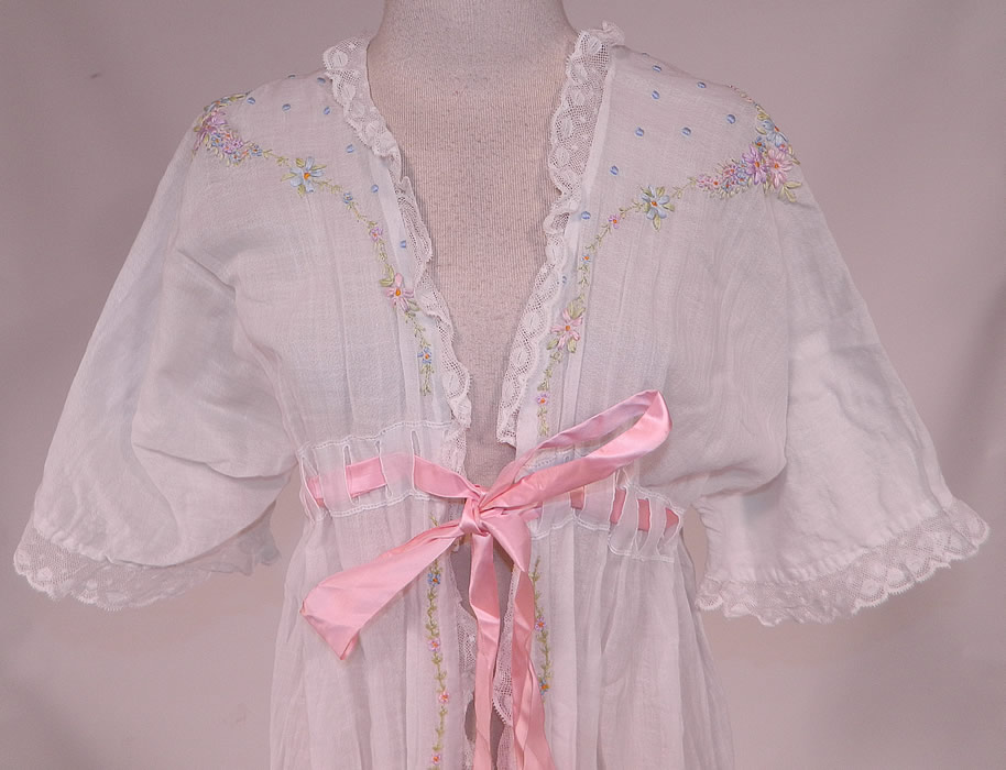 Edwardian Titanic White Cotton Rosette Embroidered Lace Peignoir Dressing Gown Robe
This beautiful boudoir peignoir robe dressing gown is loose fitting, a long floor length with a high empire waist, pink silk ribbon woven belted tie sash front closure and full short sleeves.