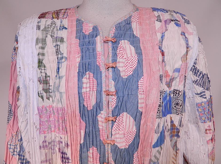 Vintage Antique Calico Crazy Quilt Patchwork Lace Smocking Ruched Pintuck Coat
There is white eyelet lace fabric inserts. This unique quilted art coat jacket is loose fitting, a long length, with a full boxy style, broad shoulders, long full sleeves, cute pink bow button closures down the front and is fully lined.