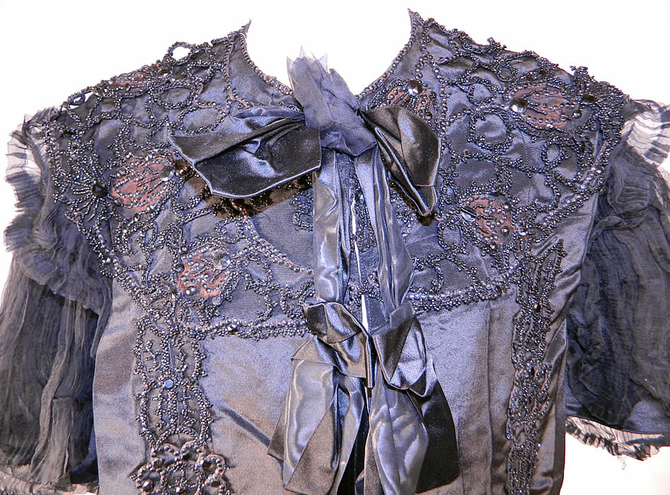 Victorian Black Silk Jet Beaded Mourning Mantle Dolman Cloak Cape Capelet
This stunning short cropped cloak cape capelet dolman mantle has black silk ribbon bow trim down the front with hook closures and is fully lined with a white silk fabric weighted along the bottom inside. 