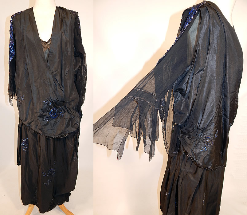 Vintage Art Deco Black Silk Taffeta Blue Sequin Beaded Flapper Dress Evening Gown
This amazing Art Deco vintage black silk taffeta blue sequin beaded flapper dress evening gown dates from the 1920s. It is made of a black silk taffeta fabric, with black and blue sequin beading done in striped, floral rose leaf pattern designs.