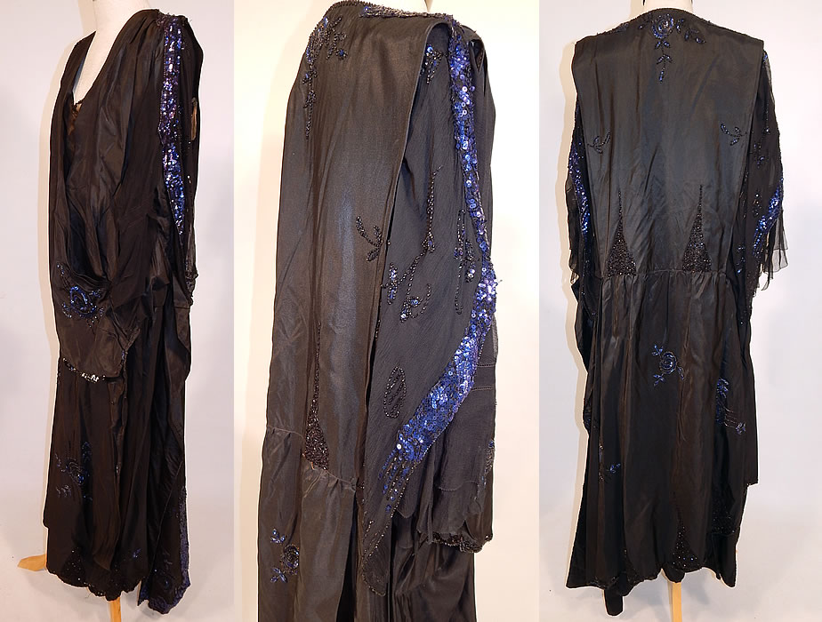 Vintage Art Deco Black Silk Taffeta Blue Sequin Beaded Flapper Dress Evening Gown
This fabulous flapper dress evening gown has a loose fitting, drop waist, draping layered wrapped style, with a plunging V front neckline, long sheer black net sleeves, flared scalloped ruffle cuffs, an uneven skirt hemline, many hooks, snap closures down the inside front and is fully lined.