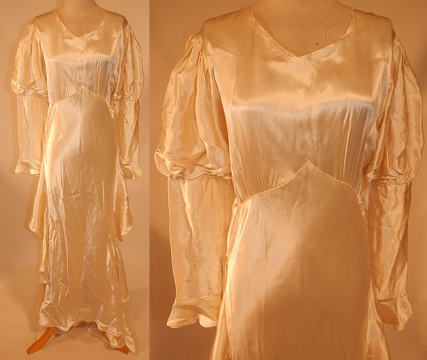 Vintage White Silk Satin Bias Cut Wedding Gown Dress Long Train Skirt
This vintage white silk satin bias cut wedding gown dress long train skirt dates from the 1930s. It is made of a luxurious white silk satin fabric. This beautiful bridal bias cut long floor length wedding gown dress has leg of mutton style sleeves, with gathered shoulders, elbows, fitted flared cuffs, a very long back train skirt which has loop strap for picking up carrying, a flared winged sides along the hips, side snap closures and thirteen silk covered button back closures.