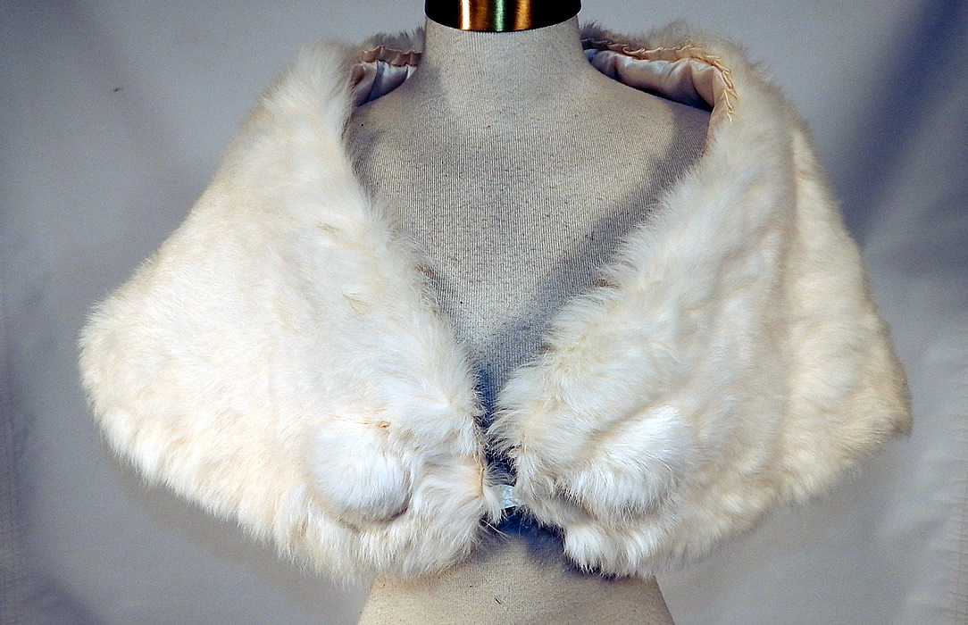 Vintage White Rabbit Fur Shrug Stole Shawl Winter Wrap Glam Evening Cape
It is made of soft white rabbit fur. This glamorous evening stole shrug shawl cape capelet has a fur pompom trim on the front of both sides, a button strap closure hidden inside the front and is fully lined in a white silk satin fabric inside, with box pleating trim edging along the back of the neck.