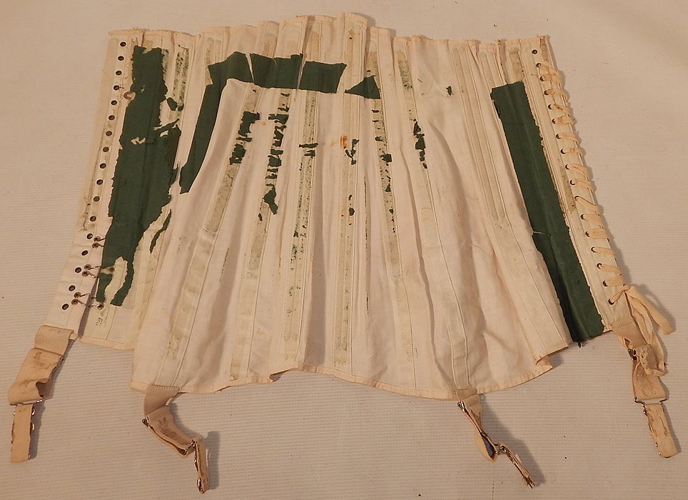 Unworn Edwardian Cream Cotton Coutil Lace Trim Longline Corset Garters
The corset measures 16 inches long, with 30 inch hips, a 24 inch waist and 22 inch under the bust which are adjustable by letting out the corset string lacing to be made larger. It is in good unworn condition, with only the original green paper remnants stuck inside. This is truly a wonderful piece of wearable antique corsetry lingerie art!