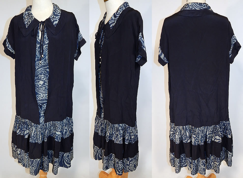 Vintage Navy Blue Art Deco Print Silk Ruffle Short Skirt Drop Waist Dress
This vintage navy blue Art Deco print silk ruffle short skirt drop waist dress dates from the 1920s. It is made of a dark navy blue silk fabric, with varying shades of lighter blue Art Deco abstract print pattern designs.