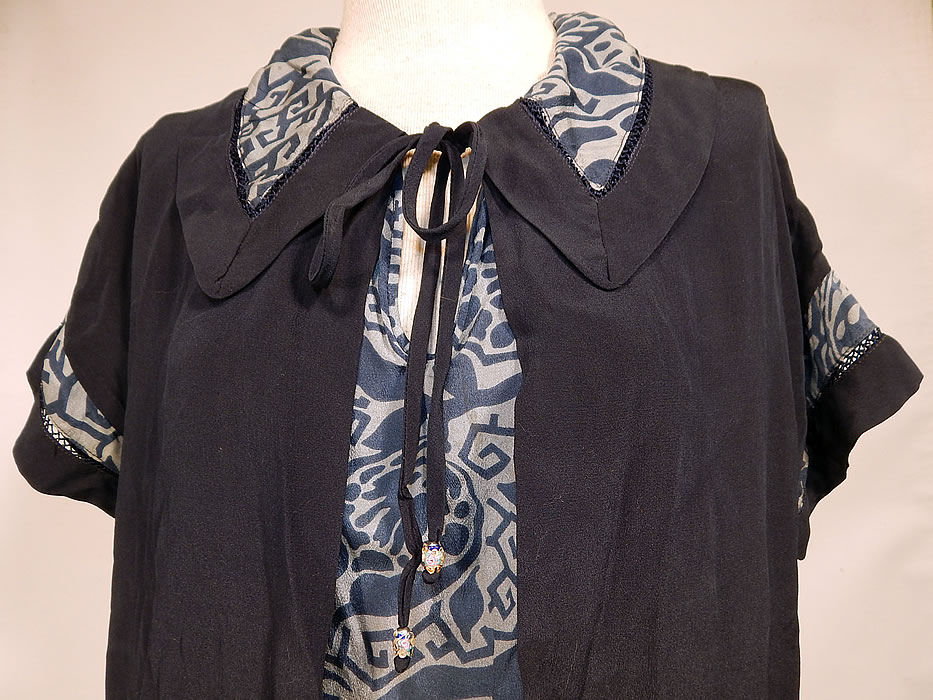 Vintage Navy Blue Art Deco Print Silk Ruffle Short Skirt Drop Waist Dress
This beautiful blue dress has a loose fitting drop waist style, with an open front print panel insert, rounded peter pan fold over collar, neck tie closure with Venetian glass millefiori beaded ends, short sleeves and a ruffle bottom short skirt. 