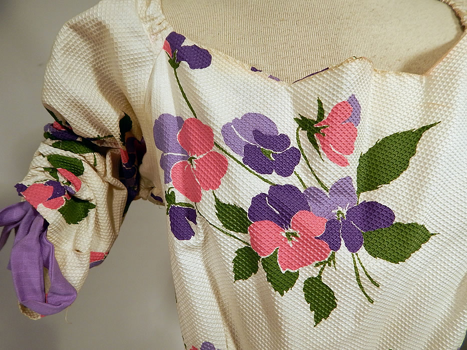 Vintage White Cotton Pique Pansy Print Full Circle Skirt Dress
This pretty party summer dress has adjustable drawstring purple straps inside the short sleeves with gathering along the shoulders, a scalloped edge neckline, very full circle skirt, side zipper closure and is unlined. 