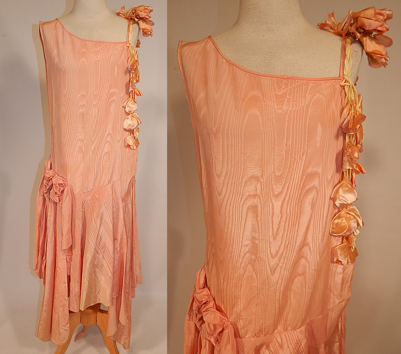 Vintage Peach Silk Moire Sweet Pea Flower Handkerchief Skirt Drop Waist Dress
This vintage peach silk moire sweet pea flower handkerchief skirt drop waist dress dates from the 1920s. It is made of a peachy pink pastel color silk taffeta moire wavy watered appearance fabric, with peach silk sweet pea flowers cascading down one shoulder.