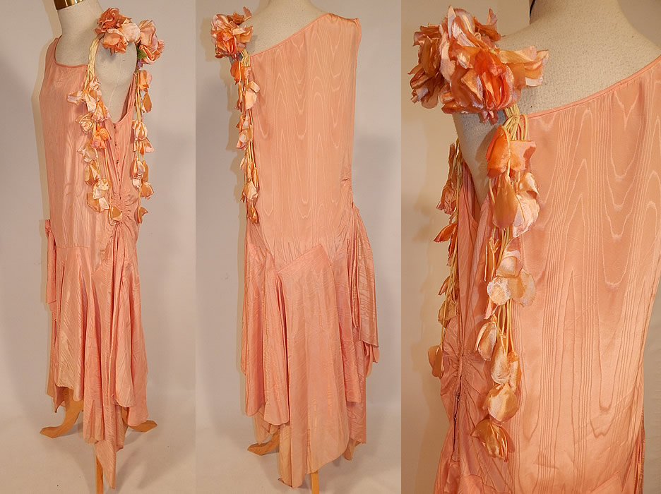 Vintage Peach Silk Moire Sweet Pea Flower Handkerchief Skirt Drop Waist Dress
This fabulous flapper drop waist dress is sleeveless, with a one shoulder style, flowers trimming the spaghetti strap along the other shoulder, an uneven asymmetrical handkerchief hemline full wrap split skirt, longer along the sides, with side gathering, side snap closures and is unlined. The dress measures 42 to 48 inches long with varying lengths, a 34 inch waist and 38 inch bust. It is in good condition, with only some slight fade discoloration along the bottom skirt creating a ombre effect. This is truly a wonderful piece of Art Deco wearable textile art! 