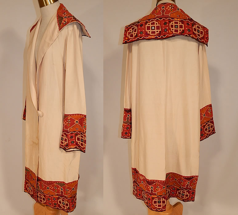 Vintage Indian Gujarati Kutch Work Embroidery Mirrored Art Deco Cocoon Coat
There are small mirrors embroidered into the decorative designs. This amazing Art Deco cocoon wrap coat is loose fitting, has a long mid length style, with a embroidered large fold over shawl sailor collar, long full sleeves with embroidered wide cuffs, an embroidered trim hem skirt, single button closure on the drop waist and is unlined. 
