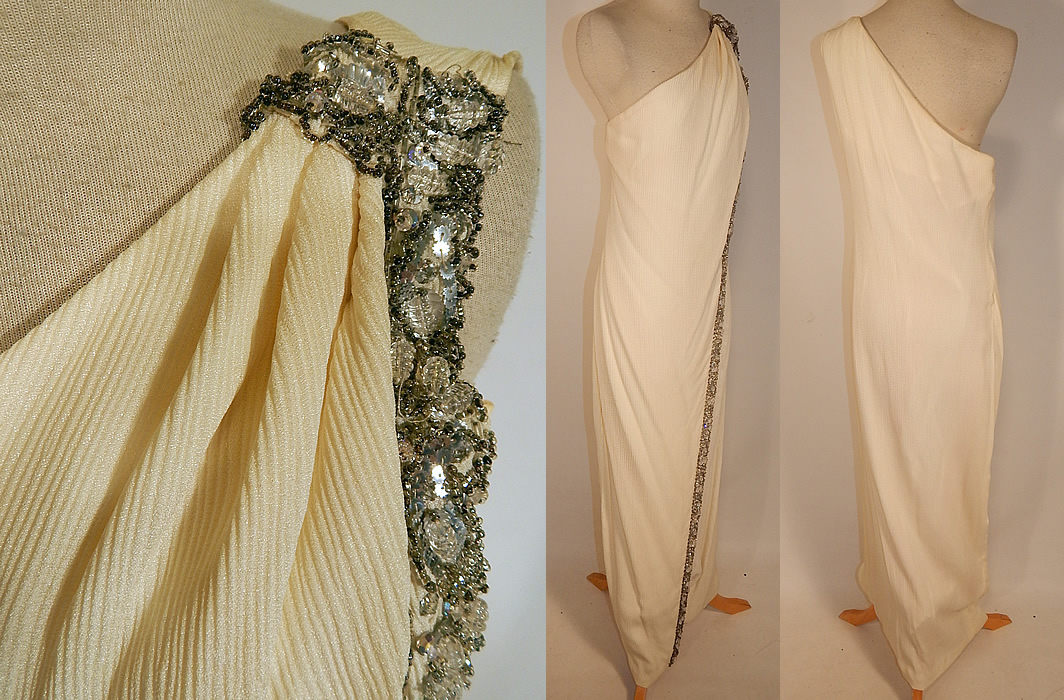 Vintage White Silk de Chine Silver Beaded One Shoulder Grecian Goddess Gown
This gorgeous Grecian goddess gown is a long floor length, with a wrap front slit skirt, one shoulder sleeveless style neckline, a side zipper closure, hooks on the shoulder and is fully lined. The dress measures 53 inches long, with 36 inch hips, a 30 inch waist and 34 inch bust. 