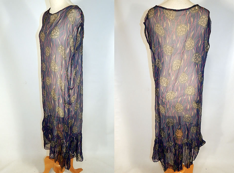 Vintage Art Deco Navy Blue Green Leaf Abstract Print Silk Chiffon Drop Waist Dress
This delightful day dress has a loose fitting straight shift, drop waist style, a sleeveless top, ruffle bottom skirt and is sheer, unlined. 