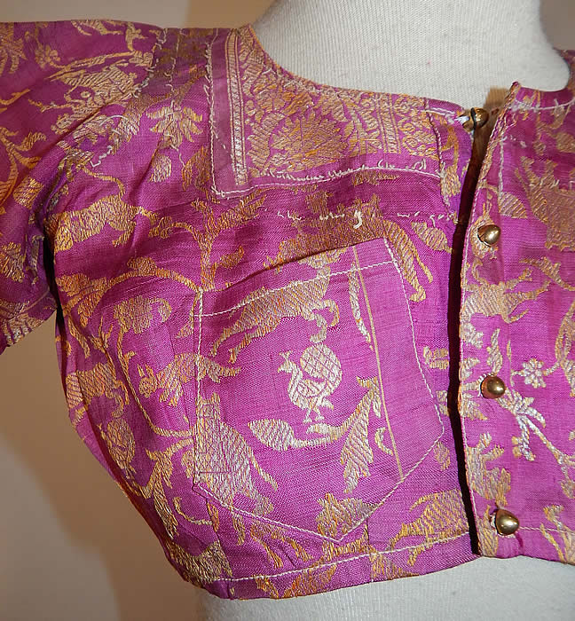 Vintage 19th Century Indian Purple Silk Sari Gold Lam&eacute; Lame Choli Crop Top Blouse
This stunning traditional handmade short cropped choli boho blouse top has a fitted style, with short sleeves, a front breast pocket, newly replaced gold plastic buttons for closure down the front and is partially lined in a linen fabric inside. 