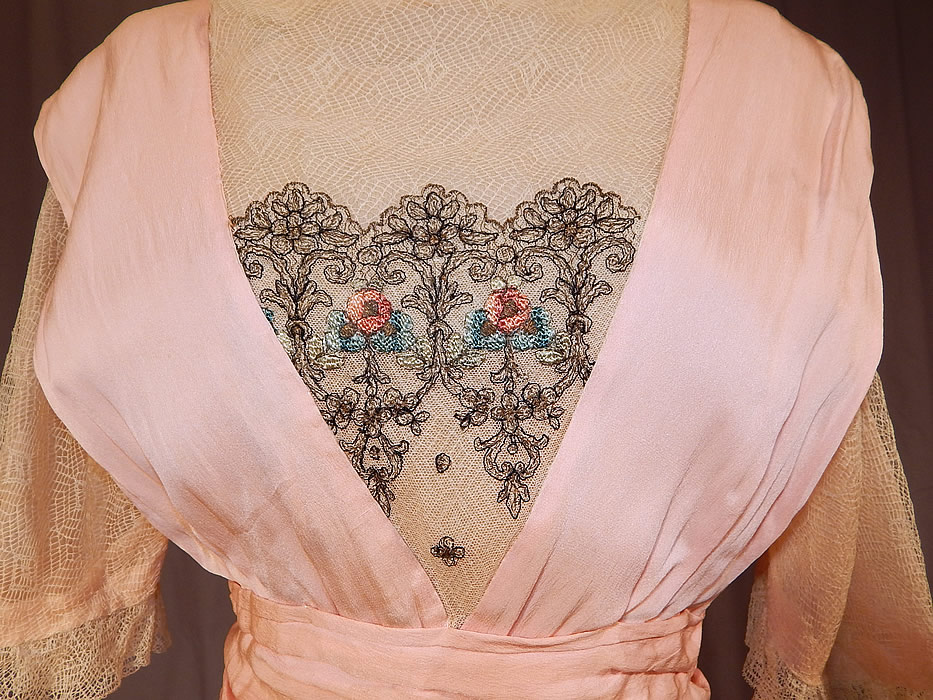 Edwardian Titanic Era Pastel Pink Silk Silver Embroidered Lace Dress
This pretty pink party dress dance ball gown has a layered, tiered style, with sheer lace ruffle top insert, a low scooped open back, net lace short sleeves, an uneven asymmetrical peplum skirted waist, long floor length skirt with side drape, snap closures on back and is unlined. 