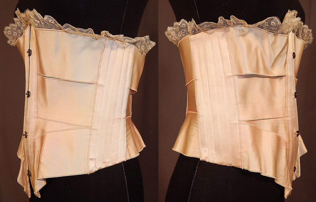 Victorian Antique Lace Trim Pink Silk Ribbon Short Negligee Night Corset Waist Cincher
This lovely lingerie negligee boudoir ribbon corset has a short style worn at night to cinch the waist while sleeping to maintain the desired smaller wasp waist. It has a slightly curved front steel busk, brass hook closures, original pink silk corset string adjustable lacing on the back, boning stays sewn along the sides and back. The brass hooks on the front closure are stamped "P.D." for the Manufactures Royales French Corsets P.D. 