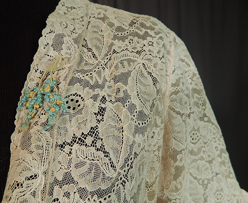 Vintage Forget Me Not Rosette Trim Cream Lace Cropped Bolero Boudoir Bed Jacket
It is made of an off white cream color sheer lace fabric, with a floral leaf pattern and a small blue forget me not French knit rosette appliqu&eacute; trim sewn onto the lapel. 