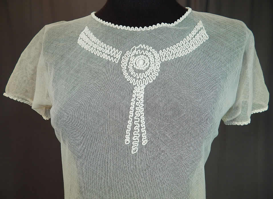 Vintage Girls White Sheer Tulle Net Soutache Ribbon Embroidery Drop Waist Dress
It is made of a white sheer tulle mesh net fabric with soutache ribbon embroidery work done in a raised garland scalloped circular rosette pattern design on the front neck and around the bottom skirt. 