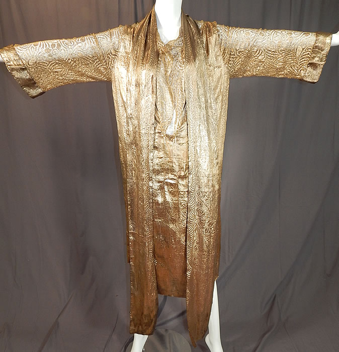 Vintage Art Deco Gold Lam&eacute; Lame Lace Belted Sash Scarf Shift Kaftan Flapper Dress
This fabulous flapper dress has a loose fitting shift kaftan tunic style, with sheer gold lace long full sleeves, a lace trimmed open front low neckline, front waist small slit opening for perhaps the sash belt to be woven through and is unlined. 