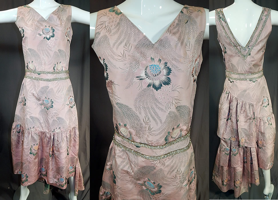 Vintage French Silk Damask Brocade Rhinestone Beaded Evening Gown Dress
This vintage French silk damask brocade rhinestone beaded evening gown dress dates from the 1920s. It is made of a luxurious 18th century inspired French silk damask jacquard weave brocade fabric with a pink background, pastel woven flowers and rhinestone beaded trim accents on the back neckline and around the waist.