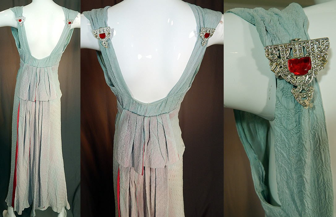 Vintage Blue Silk Crepe Matelasse Puffy Backless Bias Cut Evening Gown Dress
This beautiful blue bias cut evening gown dress is a long floor length, sleeveless, with a small key hole opening front neckline, backless with silver rhinestone red jeweled dress clips on the back shoulder straps, a belted bustle back drape with pink fuchsia satin rayon backed scarf panels, side snap closures and is unlined.