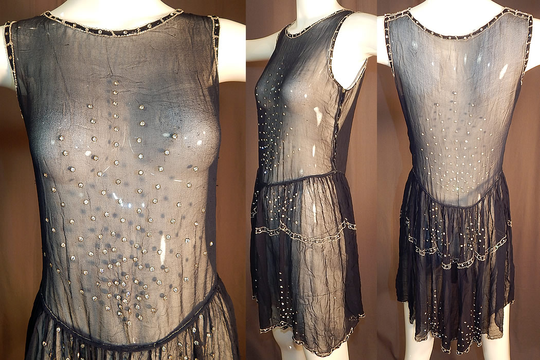 Vintage  Art Deco Navy Blue Sheer Silk Chiffon Rhinestone Beaded Flapper Dress
This fabulous flapper dress has a fitted top sleeveless style, beaded scalloped short full skirt, shoulder, side snap closures and is sheer, unlined. The dress measures 35 inches long, with a 28 inch waist and 36 inch bust. 