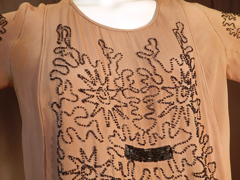 Vintage Art Deco Fleshy Pink Ecru Silk Steel Cut Beaded Tabard Top Flapper Dress
It is made of a fleshy pink, ecru color silk crepe de chine fabric, with a dark silver tone steel cut beading done in Art Deco abstract scrolling starburst designs on the top. 
