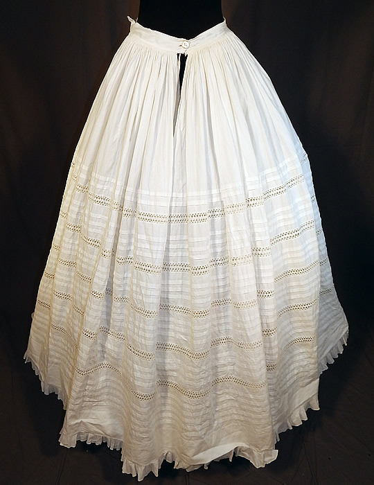 Victorian White Cotton Crochet Drawnwork Pleated Petticoat Full Hoop Skirt
This pretty petticoat skirt has a long floor length full hoop skirt (hoop not included underneath), fitted waistband marked with the owners name and mother of pearl button closure on the back waist. 