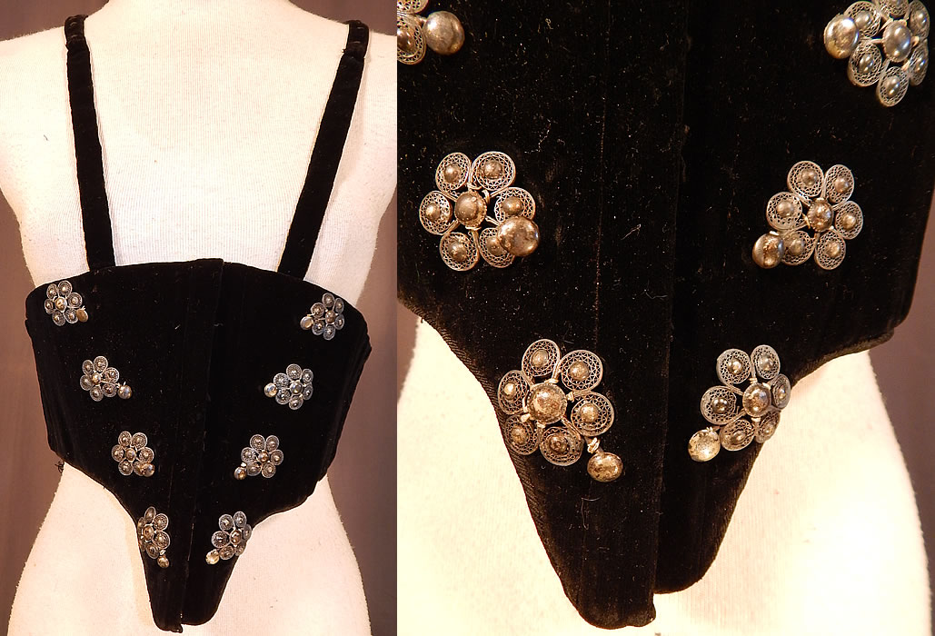 Victorian Black Velvet Silver Trim Swiss Waist Corselet Corset Vest Bodice
This antique Victorian Civil War era black velvet silver trim Swiss waist corselet corset vest bodice dates from the 1860s. It is made of a black velvet fabric, with silver metal raised filigree flower shaped button trim on the front.