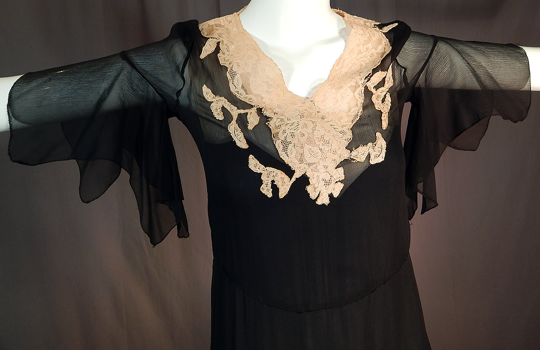 Vintage Black Silk Chiffon Cream Lace Handkerchief Sleeve Bias Cut Dress Slip
This beautiful black bias cut dress is a shorter mid length, with a side tiered layered ruffle skirt, lace trim V front neckline, fluttery handkerchief style short sleeves, side snap closures and is sheer, unlined. 