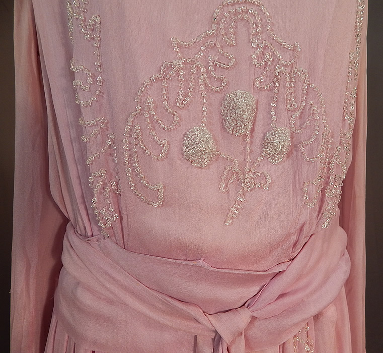 Edwardian Lilac Silk Chiffon Crystal Beaded Belted Evening Gown Dress
This lovely lilac evening gown dress is a long floor length with a fitted inside waistband, long full sleeves with wide cuffs, a layered tiered skirt with peplum draped sides, an attached belted tie sash with beaded tassel end, snap closures along the side top and is fully lined with a lilac silk short slip sewn inside. 