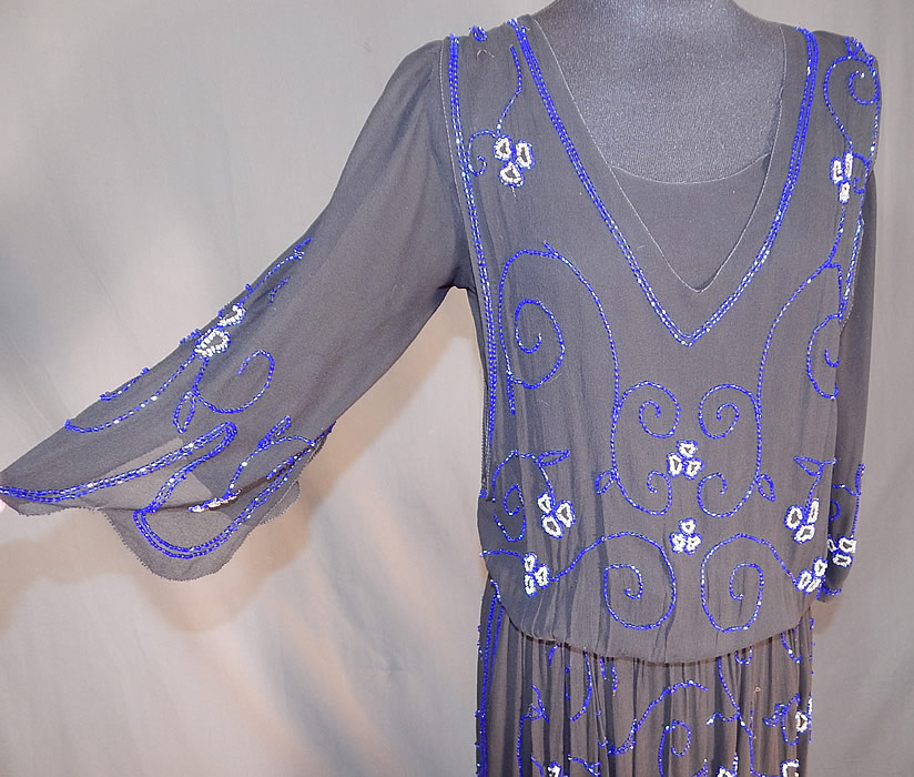 Vintage Art Deco Black Silk Pink & Cobalt Blue Beaded Spiral Floral Flapper Dress
This fabulous flapper dress has a layered overblouse style, with 3/4 length full sleeves, scalloped edging, side and shoulder snap closures, a fitted waistband inside and is fully lined. 