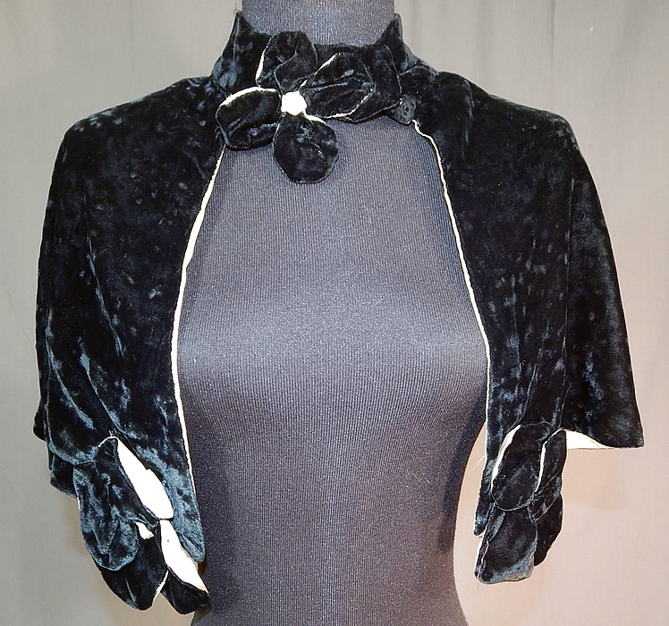 Vintage Black Silk Velvet Flower Trim Short Cropped Cape Evening Shawl Capelet
This vintage black silk velvet flower trim short cropped cape evening shawl capelet dates from the 1930s. It is made of a black silk velvet fabric, backed, lined in a white silk fabric.