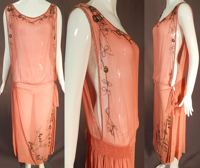 Vintage Art Deco Pink Silk Chiffon Gold Lam&eacute; Rosette Beaded Drop Waist Flapper Dress
This vintage Art Deco pink silk chiffon gold lam&eacute; rosette beaded drop waist flapper dress dates from the 1920s. It is made of a sheer pink silk chiffon fabric, with raised gold metallic lam&eacute; rosette flower trim, rhinestone centers and silver beading done in a garland bow, vine leaf design along the top edging and bottom front skirt. 