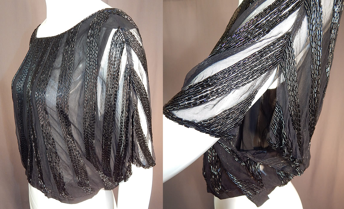 Vintage Art Deco Sheer Black Silk Beaded Batwing Sleeve Blouse Shirt Top
This beautiful beaded blouse has a loose fitting style with batwing split short sleeves, a cropped fitted waistband with side snaps, a key hole opening button back and is fully lined with a black silk chiffon camisole lining. 