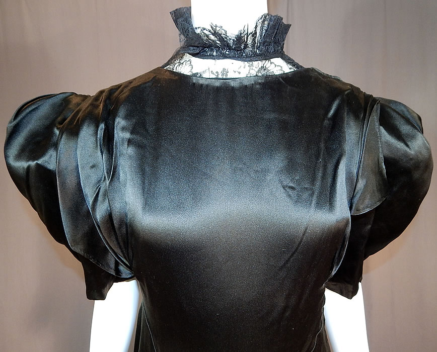 Vintage Black Silk Charmeuse Lace Ruffle High Collar Bias Cut Cocktail Dress
This beautiful black bias cut cocktail dress is a long length, with a lace trimmed high neck ruffle collar, pleated crinoline lined shoulders, short puffy layered sleeves, a key hole opening back slit, shoulder snaps, side zipper closure and is lined on the top only.