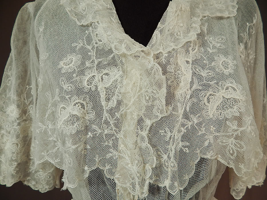 Titanic Edwardian Embroidered White Tulle Net Lace Crop Top Dress Tea Gown
This lovely lace dress is a tea gown length, with a layered crop top bolero jacket style, scalloped edging, fold over collar, short sleeves, ruffled trim fitted waistband, layered tiered short overskirt, hook closures down the front, around the waist and is sheer, unlined. 
