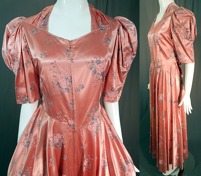 Vintage Pink Pastel Floral Rose Bouquet Print Satin Maxi Dress Gown
This pretty pink maxi dress floor length dressing gown has a long full skirt, with gathered shoulders, short puffy sleeves, a V front waist with belted back tie sash, front zipper closure and is unlined. 