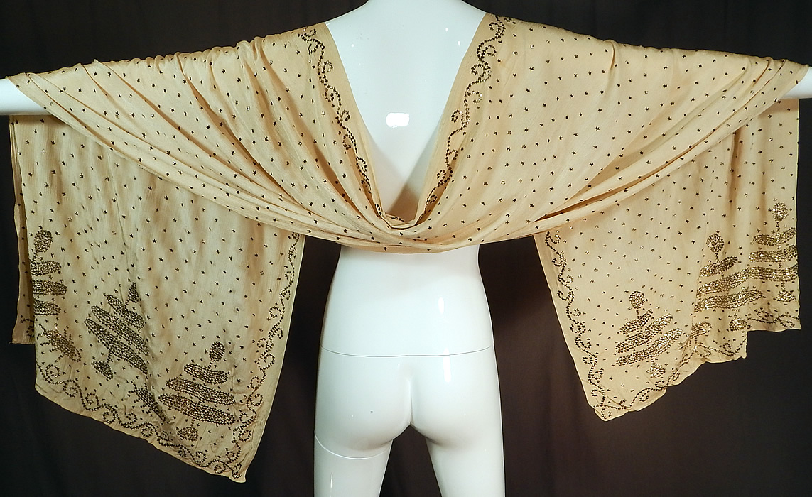 Vintage Art Deco Turkish Tel-Kirma Assuit Cream Silk Silver Stud Shawl Scarf
This amazing antique Art Deco Turkish tel-kirma assuit cream silk silver stud shawl scarf dates from the 1920s. It is made of an off white cream color silk fabric, covered with hand applied silver metal pieces done in a decorative Coptic designs along the ends, stars throughout and a scrolling spiral border edging.