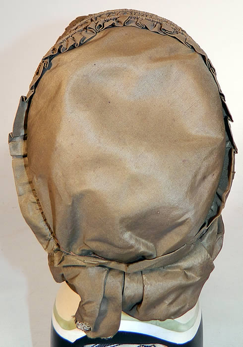 Victorian Civil War Green Silk Pleated Ruched Drawn Shirred Spoon Bonnet. There are no silk ribbon ties for securing onto the head. The bonnet measures 22 inches around the front opening and is 13 inches deep. 