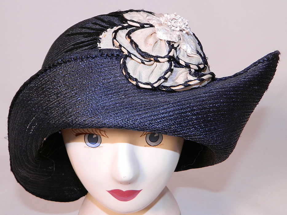 Vintage Black Straw Upturned Brim White Silk Flower Flapper Cloche Hat. This vintage black straw upturned brim white silk flower flapper cloche hat dates from the 1920s.