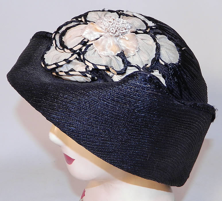 Vintage Black Straw Upturned Brim White Silk Flower Flapper Cloche Hat. This beautiful black & white cloche style hat has a unique uneven brim which has an upturned brim along the front and side creating a winged point.