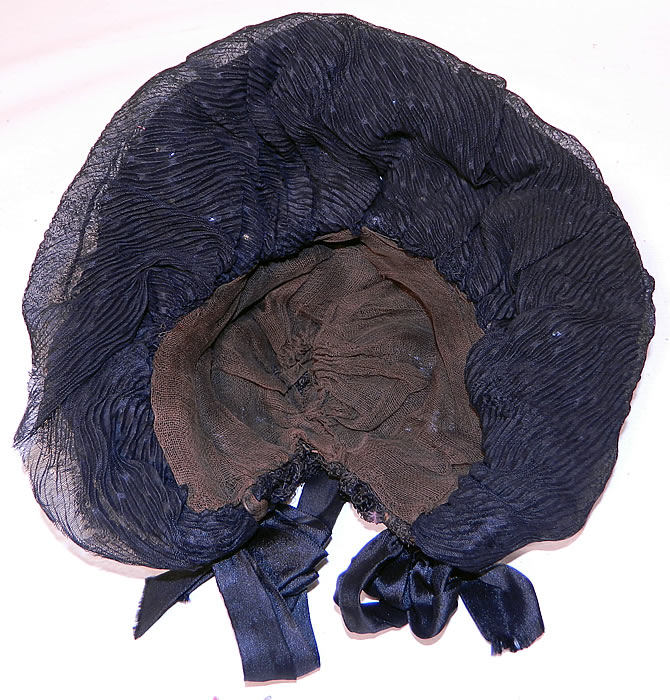 Victorian Black Silk Crepe Pink Flower Trim Mourning Bonnet Hat. This beautiful bonnet has black silk ribbon ties for securing under the chin. It is fully lined in a muslin fabric. The bonnet measures 25 inches in circumference. It is in good condition. This is truly a wonderful piece of wearable millinery art!