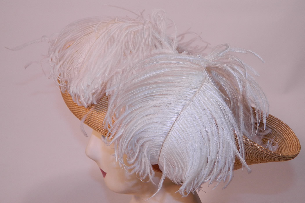 Edwardian Titanic Natural Straw Upturned Wide Brim White  Ostrich Feather Hat. It is made of a tightly woven natural straw basket weave, with white fluffy ostrich feather plume trim around the crown. 