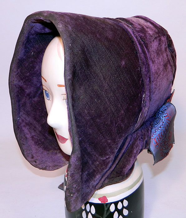 Victorian Civil War Era Antique Purple Violet Silk Velvet Drawn Spoon Bonnet. This beautiful bonnet hat has a rigid stiffened front brim with curving spoon style sides and a curtain, cape, flounced fabric drape back. 