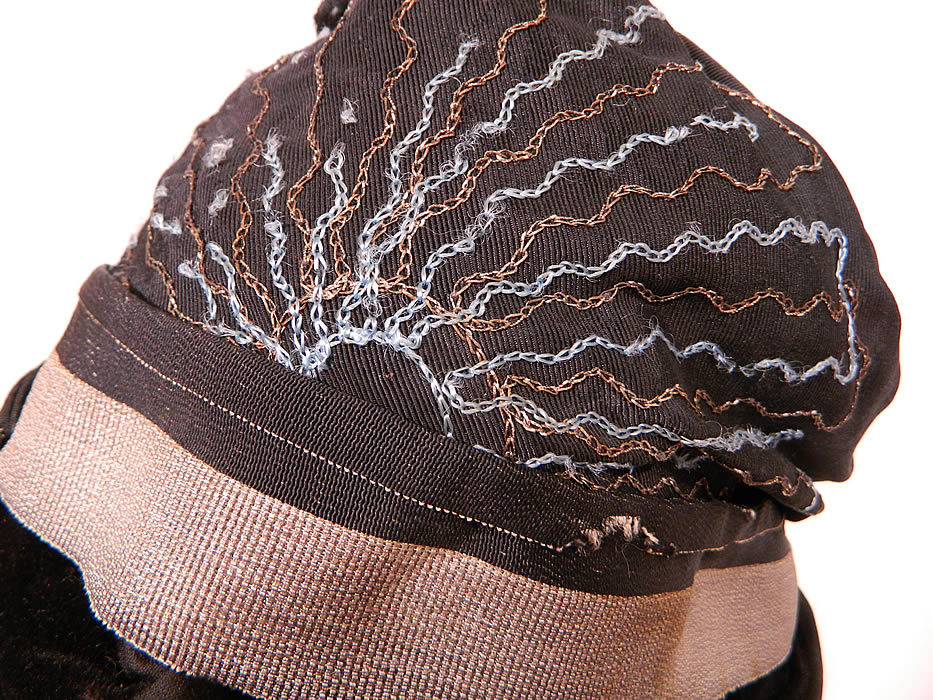 Vintage Dahlia Model Black Silk Velvet Gold Lame Lam&eacute; Embroidered Flapper Cloche Hat. It is in good unworn condition, with only a few missing blue thread embroidered stitches (see close-up).
