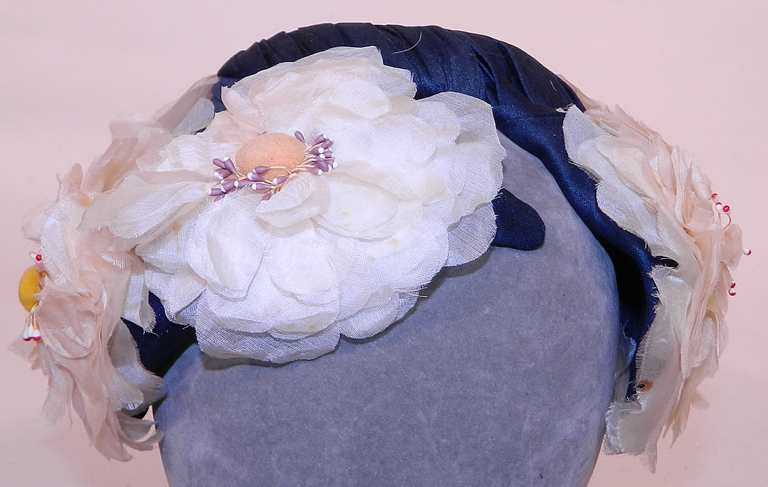Vintage Rosa et Valentine Paris Label Blue Silk White Magnolia Flower Fascinator Hat. It is made of a navy blue silk crepe de chine fabric covering the base and white silk magnolia flowers trimming around it. 