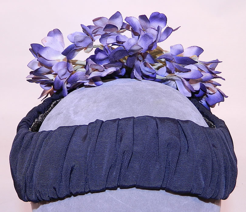 Vintage Black Silk Grosgrain Ribbon Purple Violet Flower Fascinator Hat
It is made of a gathered black silk grosgrain ribbon ribbed fabric covering the base and purple silk violet flowers bouquet hanging down the back. 
