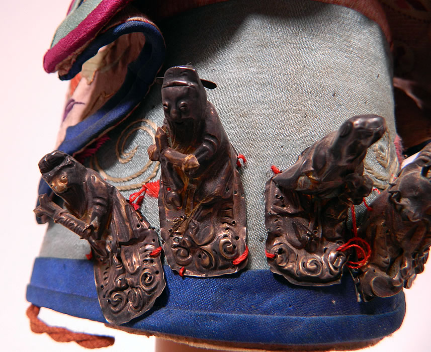 Antique Chinese Child Infant Silk Embroidered Silver Immortals Charm Wind Hat
There are hollow silver figures of the Immortals sewn onto the front and a decorative charm hanging down the back. 