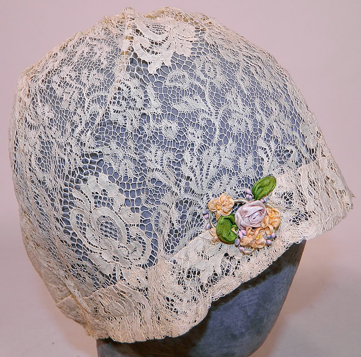 Vintage Lace Silk Rosette Trim Floral Flapper Boudoir Bed Cap Cloche Hat
The hat is made of a sheer off white cream color lace with a floral pattern and pastel silk ombre rosette ribbon work trim bouquets on each side. 