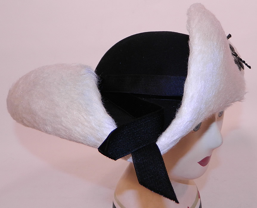 Vintage Leon Hats NY Label Black & White Felt Fur Jet Beaded Trim Tricorn Hat
This unique updated reproduction of an 18th century style tricorn hat has a three cornered upturned rolled brim and small rounded top crown, with elastic strap attached underneath to secure onto the head. 